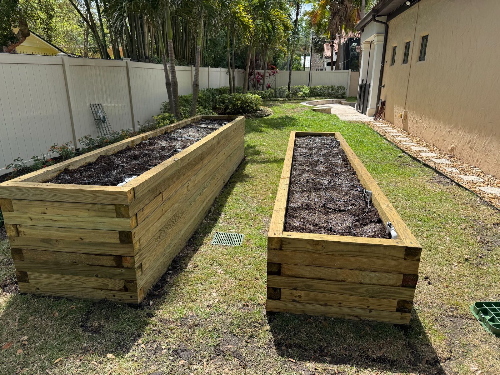 Two custom raised planter beds with fresh soil and drip lines installed