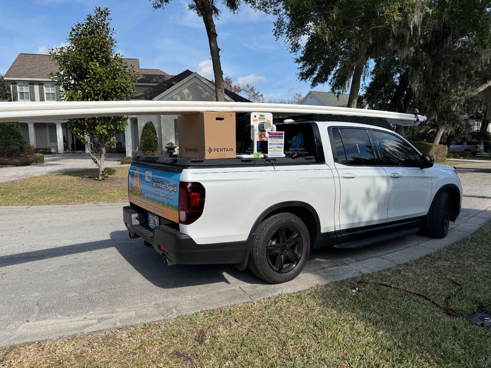 Sprinkler Squid truck loaded with PVC pipe parked in a Central Florida driveway